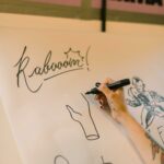 Close-up of a hand drawing comic art with a marker on paper.