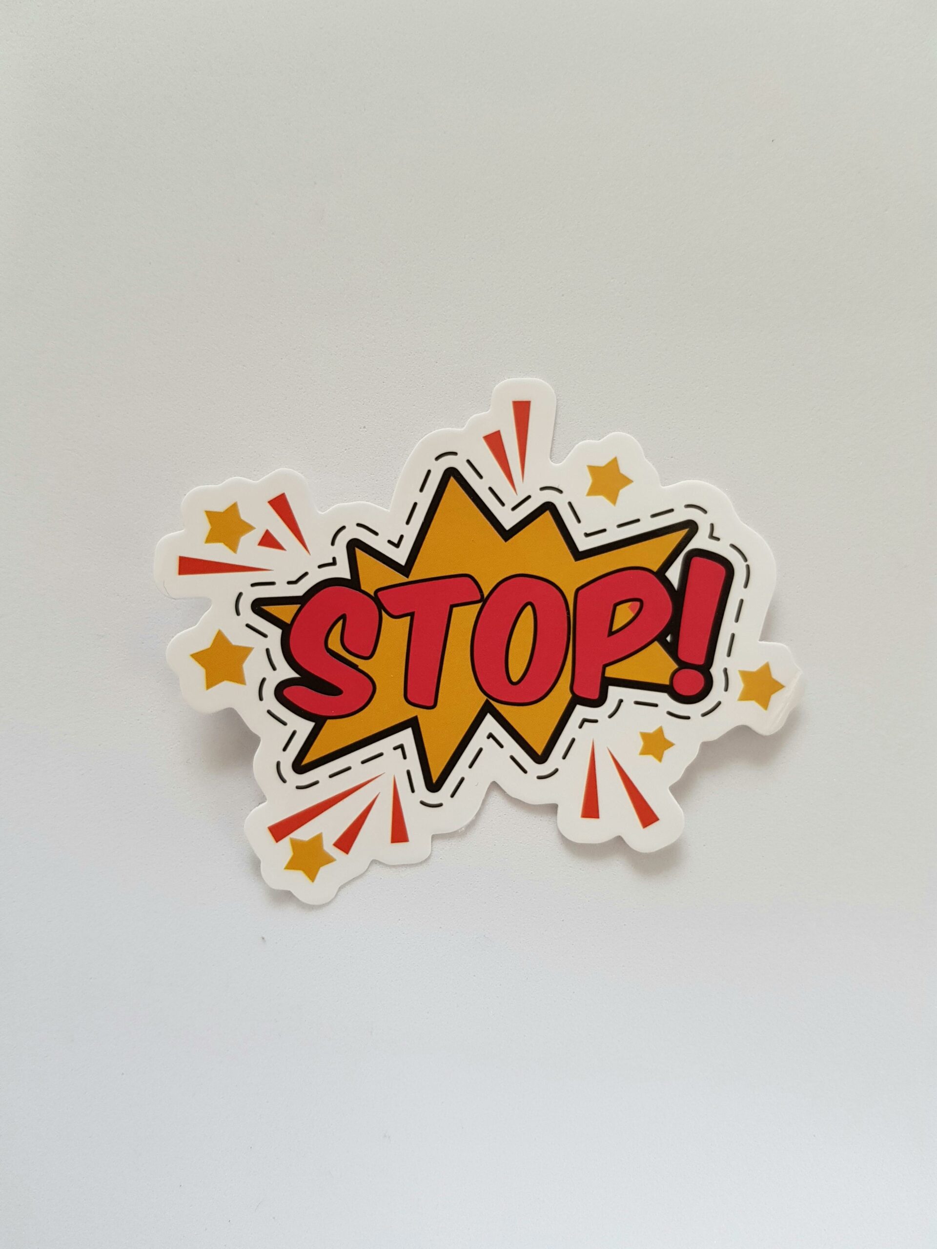 Bright and colorful sticker design featuring a comic-style 'Stop!' sign on a gray background.