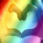 Hands forming a rainbow heart shape, symbolizing love, unity, and LGBTQ pride.